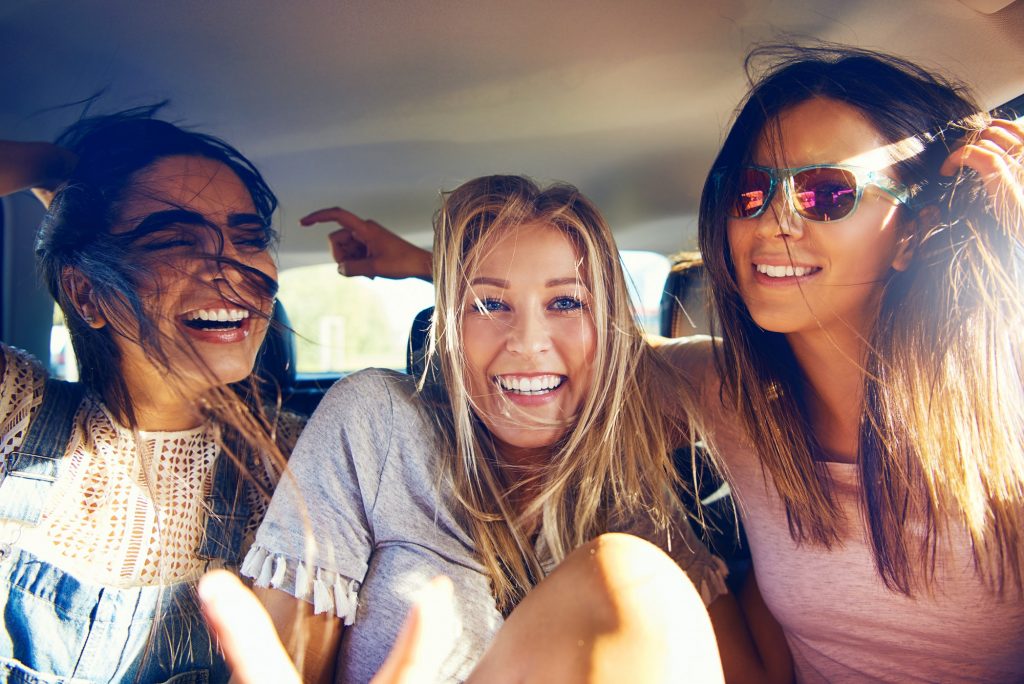 Three beautiful happy girls in a car