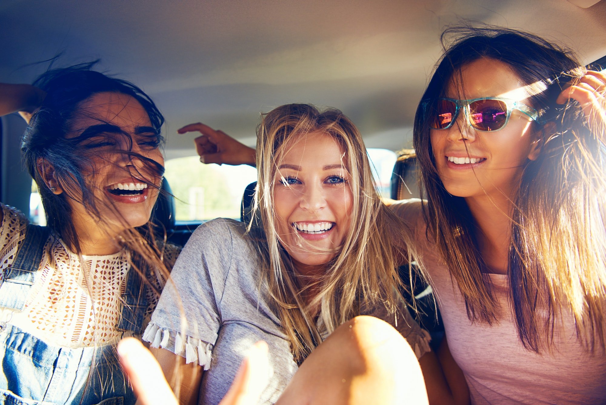 Drei schöne glückliche Mädchen in einem Auto